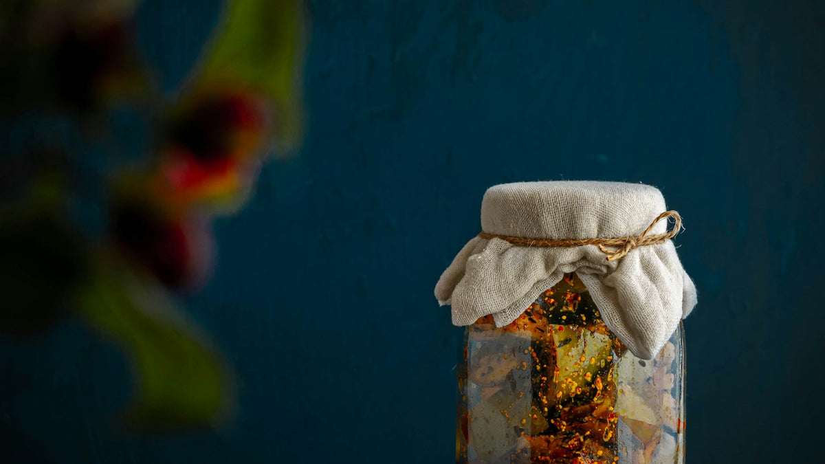Glazen pot met gedroogde thee op een houten tafel