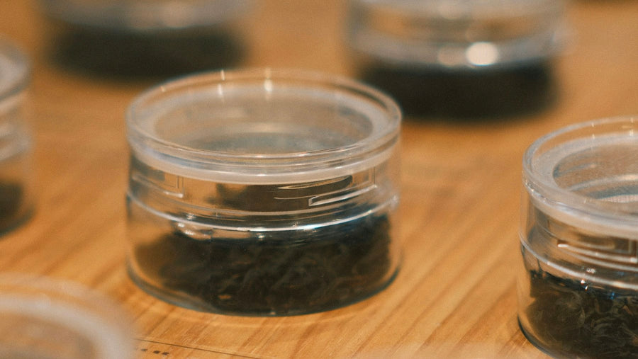 Afgesloten potjes met losse thee op een houten blad