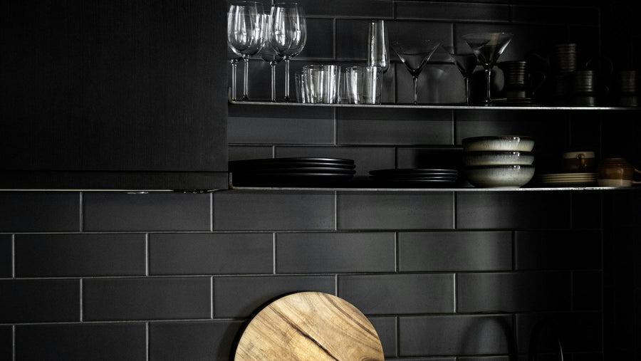 Zwarte keuken met een houten snijplank