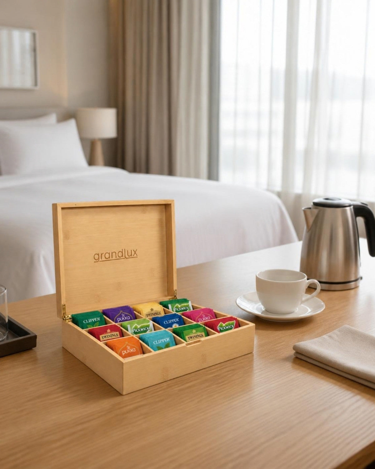 Grandlux theedoos naturel gevuld met thee op het bureau van een hotelkamer