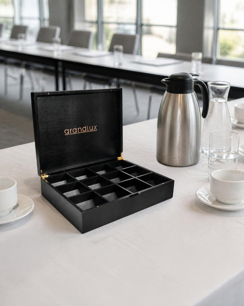Grandlux theedoos zwart op de koffietafel van een vergaderlocatie