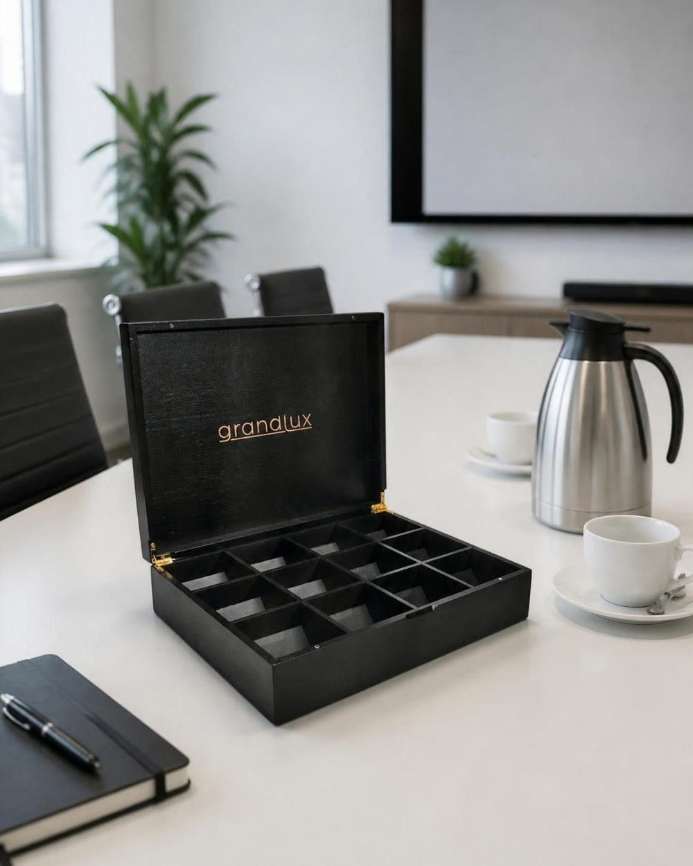 Grandlux theedoos zwart op een vergadertafel